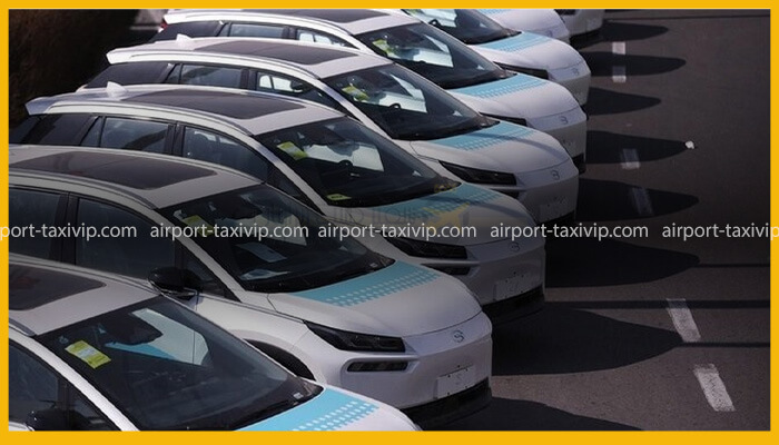 ناوگان تاکسی‌های برقی سفید رنگ آیون (Aion) در حال استراحت در توقفگاه